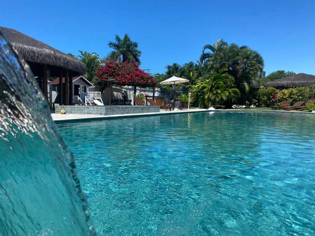 Piscina do Village Mutá em área de lazer cercada por jardins