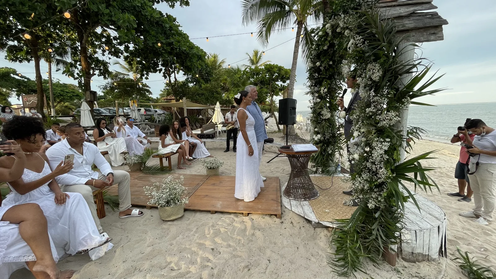 Cerimônia de casamento com flores brancas e folhagens à beira-mar no Hibisco Praia