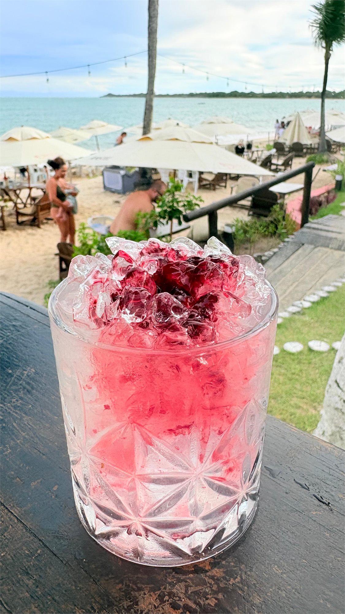 Drink de frutas vermelhas com a Praia do Mutá ao fundo