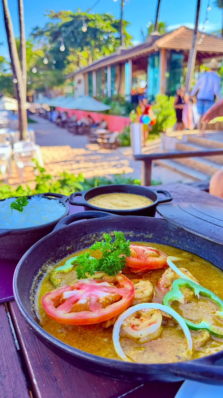 Moqueca servida com arroz e acompanhamentos no Hibisco Praia
